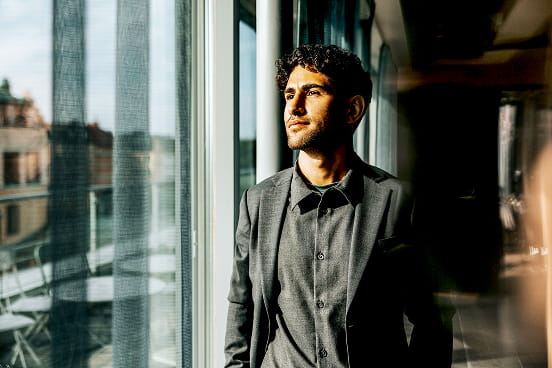 un homme entrepreneur regardant par la fenêtre de son bureau