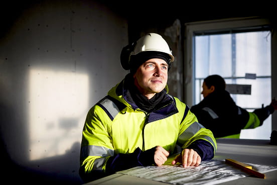 un homme travaillant dans le secteur du BTP portant un casque et un équipe de sécurité
