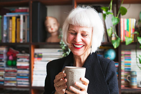 une femme souriante buvant un café
