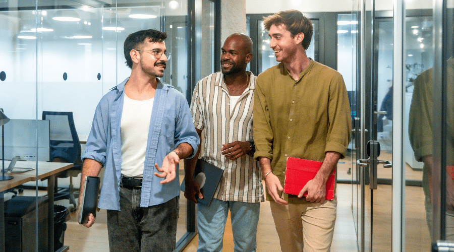 Three colleagues talking while walking through an office