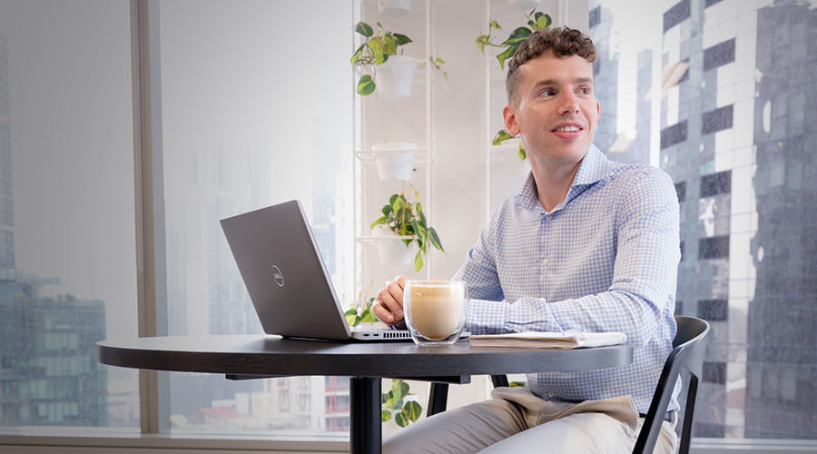 A man working on a laptop while looking to the side.