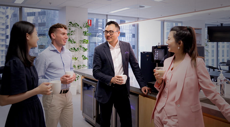 Four staff in discussion in a pantry.
