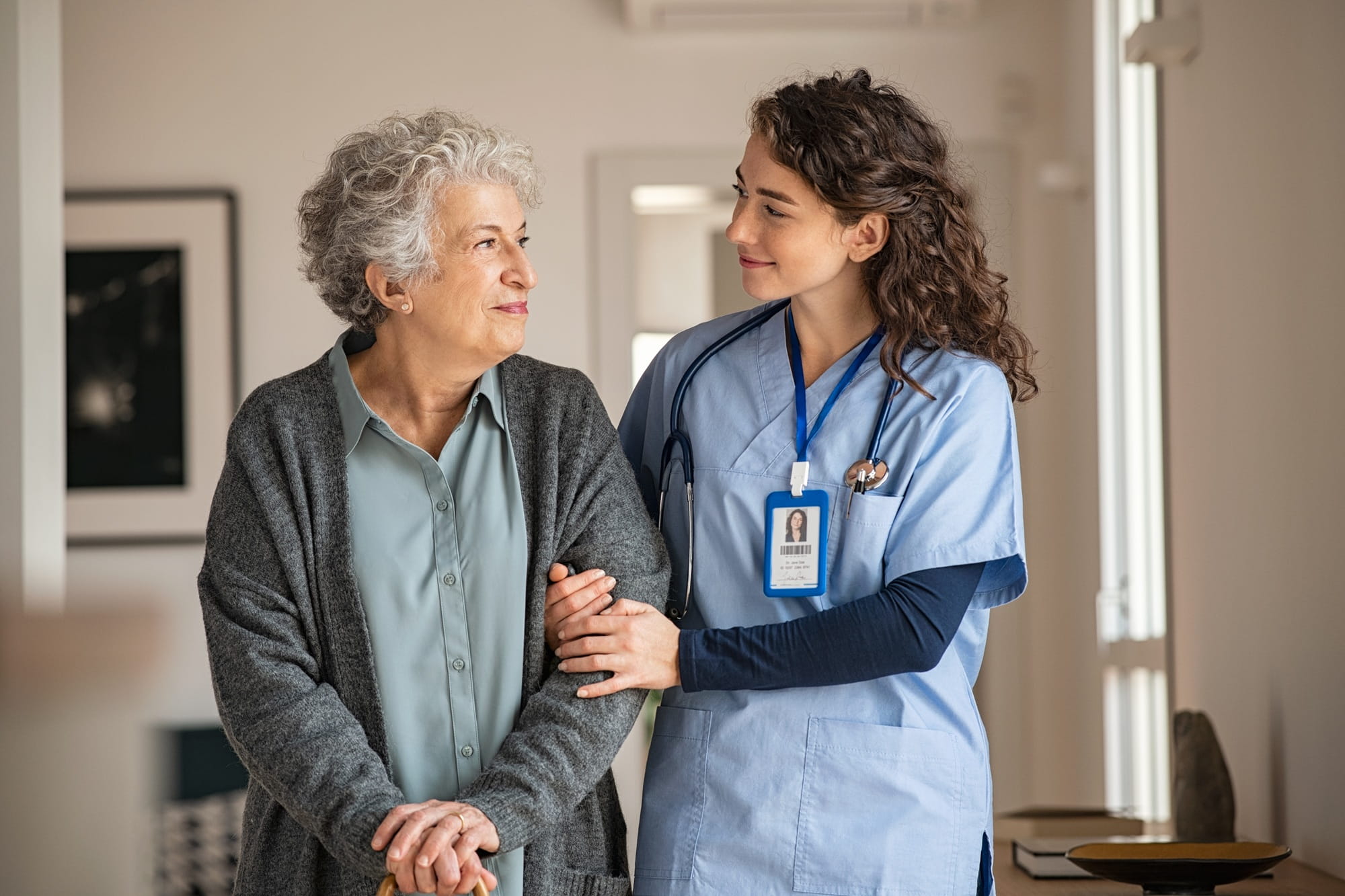 Une femme médecin marche aux côtés d’une femme âgée dans un couloir, lui apportant son soutien. Une femme médecin marche aux côtés d’une femme âgée dans un couloir, lui apportant son soutien.