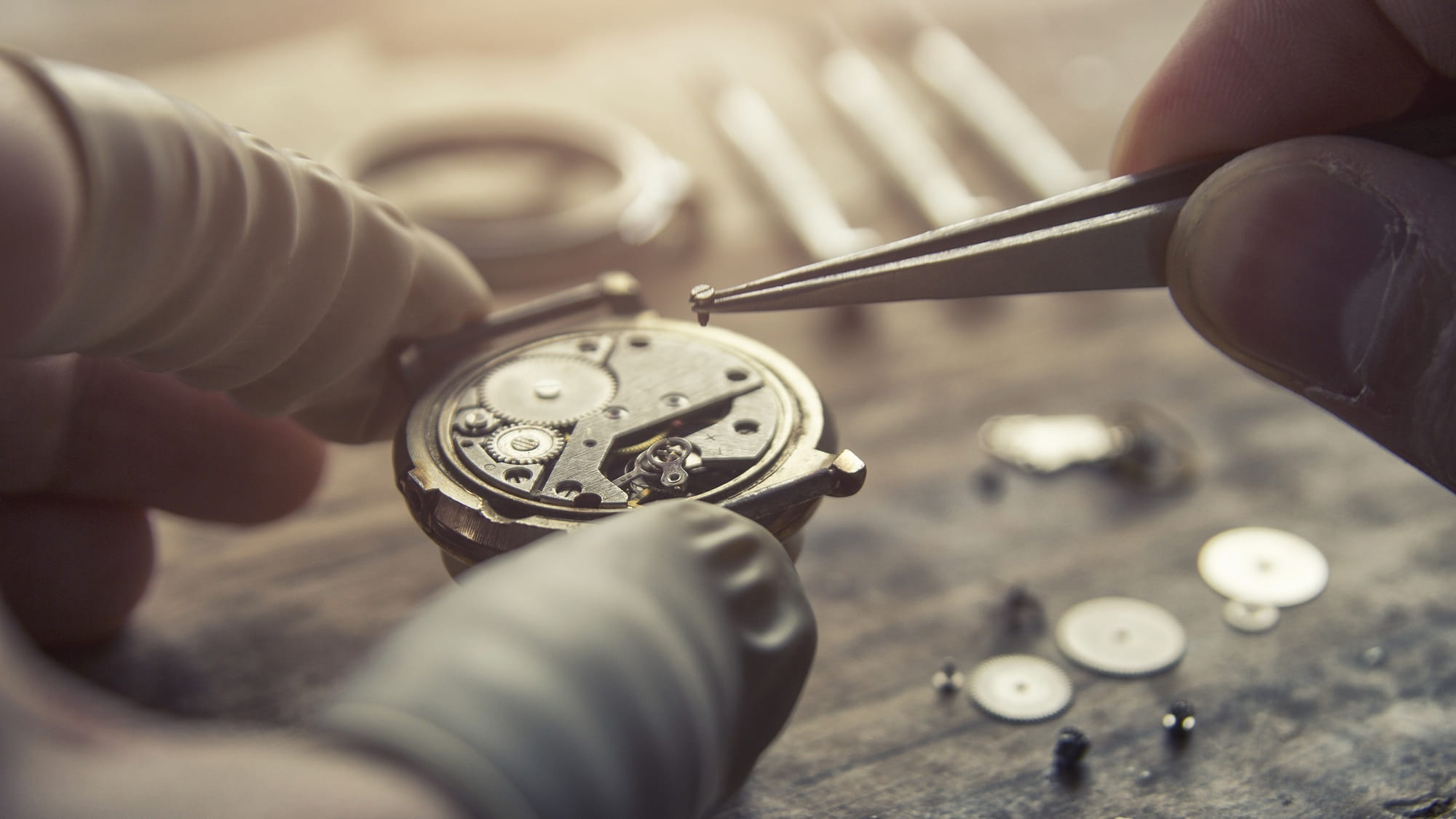 Un orologiaio assembla con cura un orologio da polso nel suo laboratorio. Un orologiaio assembla con cura un orologio da polso nel suo laboratorio.