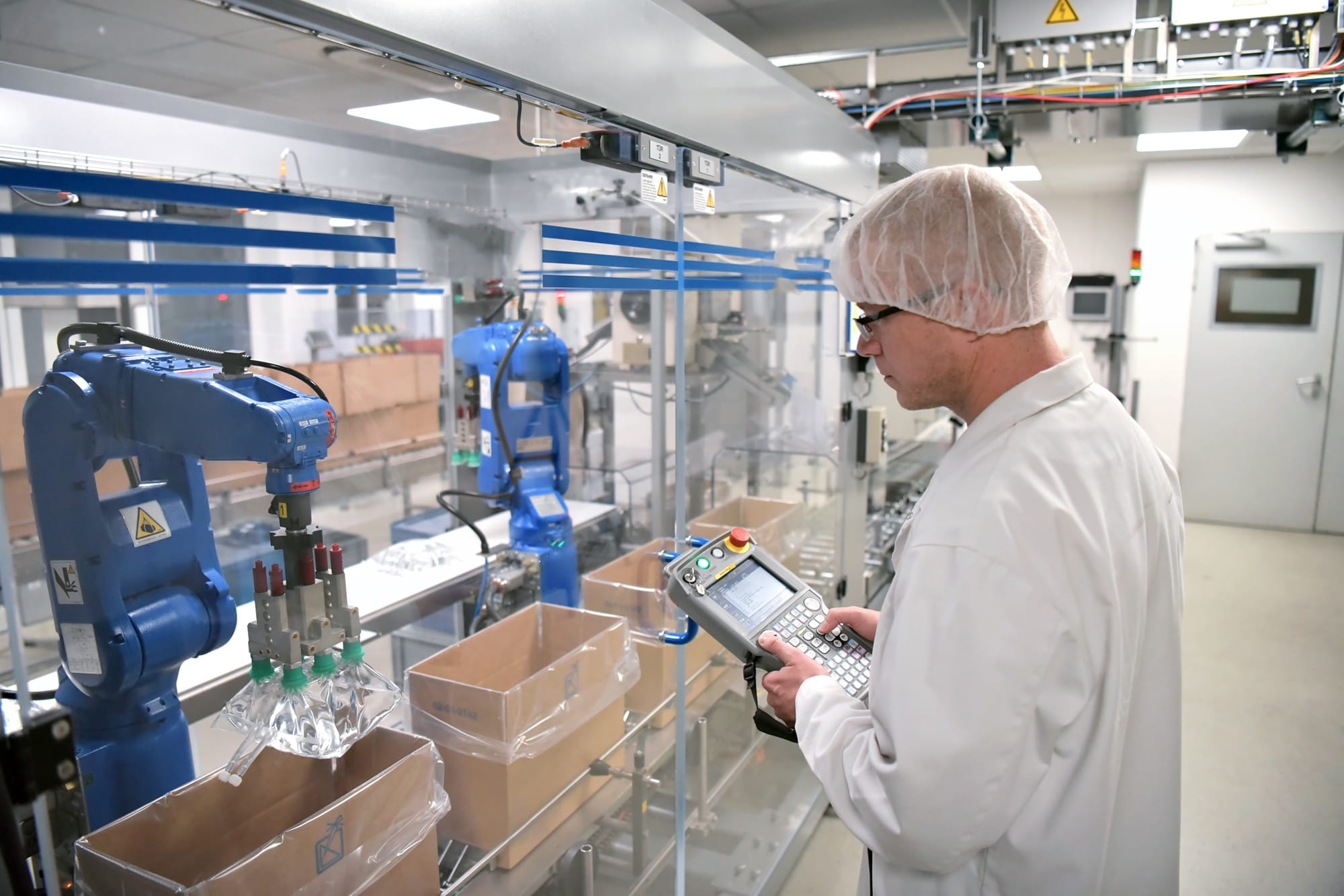 Un uomo supervisiona la produzione farmaceutica in uno stabilimento. Un uomo supervisiona la produzione farmaceutica in uno stabilimento.