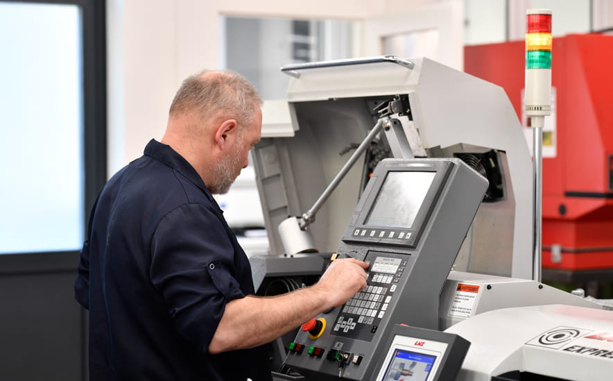 Ein Mann in der Uhrenindustrie steht an einer Maschine. Ein Mann in der Uhrenindustrie steht an einer Maschine.