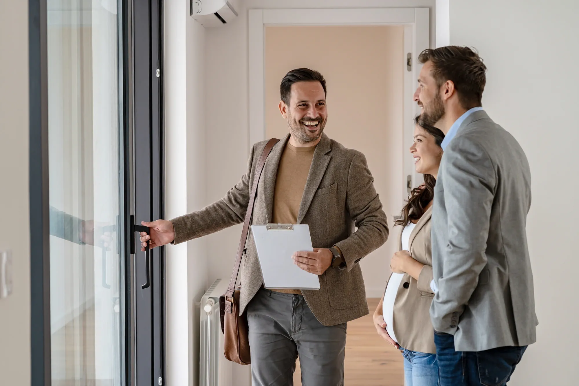 A real estate agent is showing an apartment to a couple. A real estate agent is showing an apartment to a couple.
