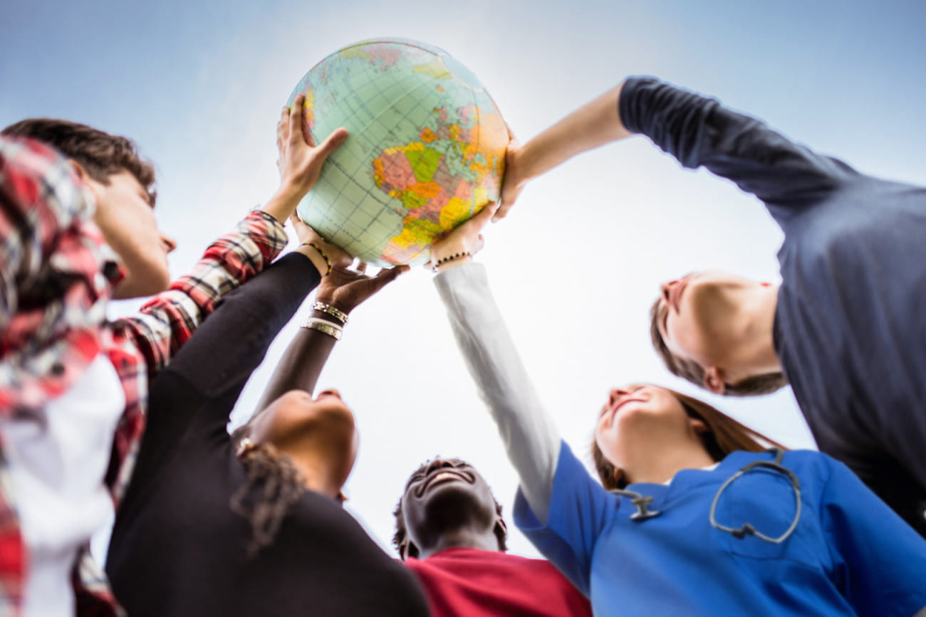 Menschen halten zusammen einen Globus