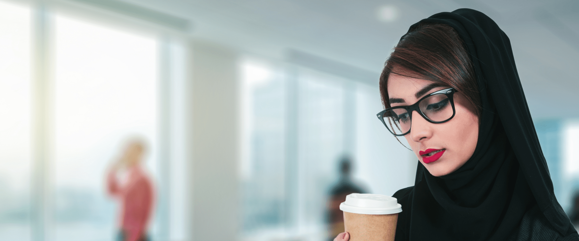 Arab attractive businesswoman drinking a coffee and using a digital tablet while standing in the office