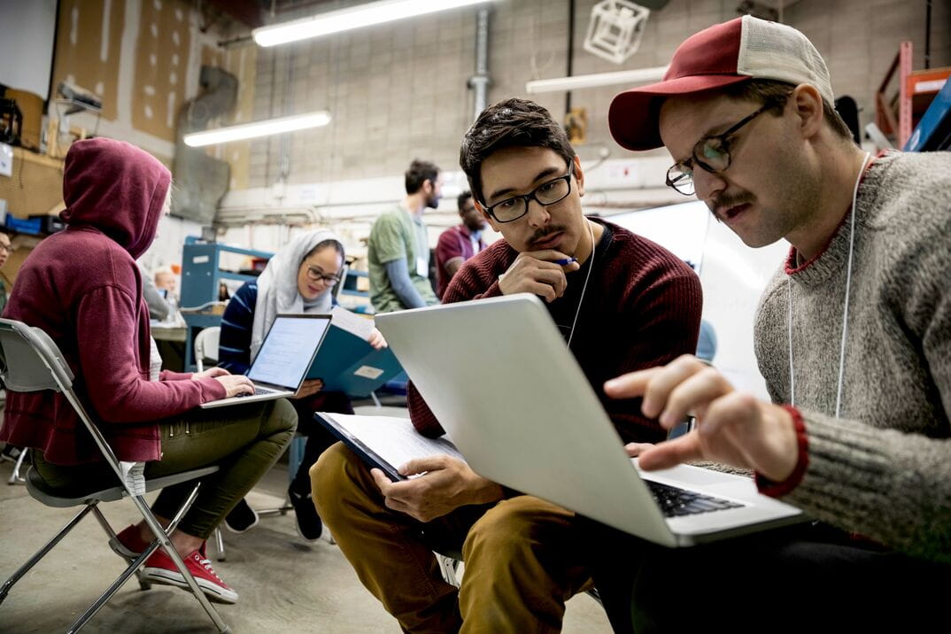 Small group of people collaborating on laptops in a workshop setting