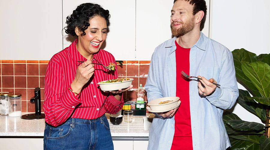 Collega’s praten en eten samen in keuken Collega’s praten en eten samen in keuken