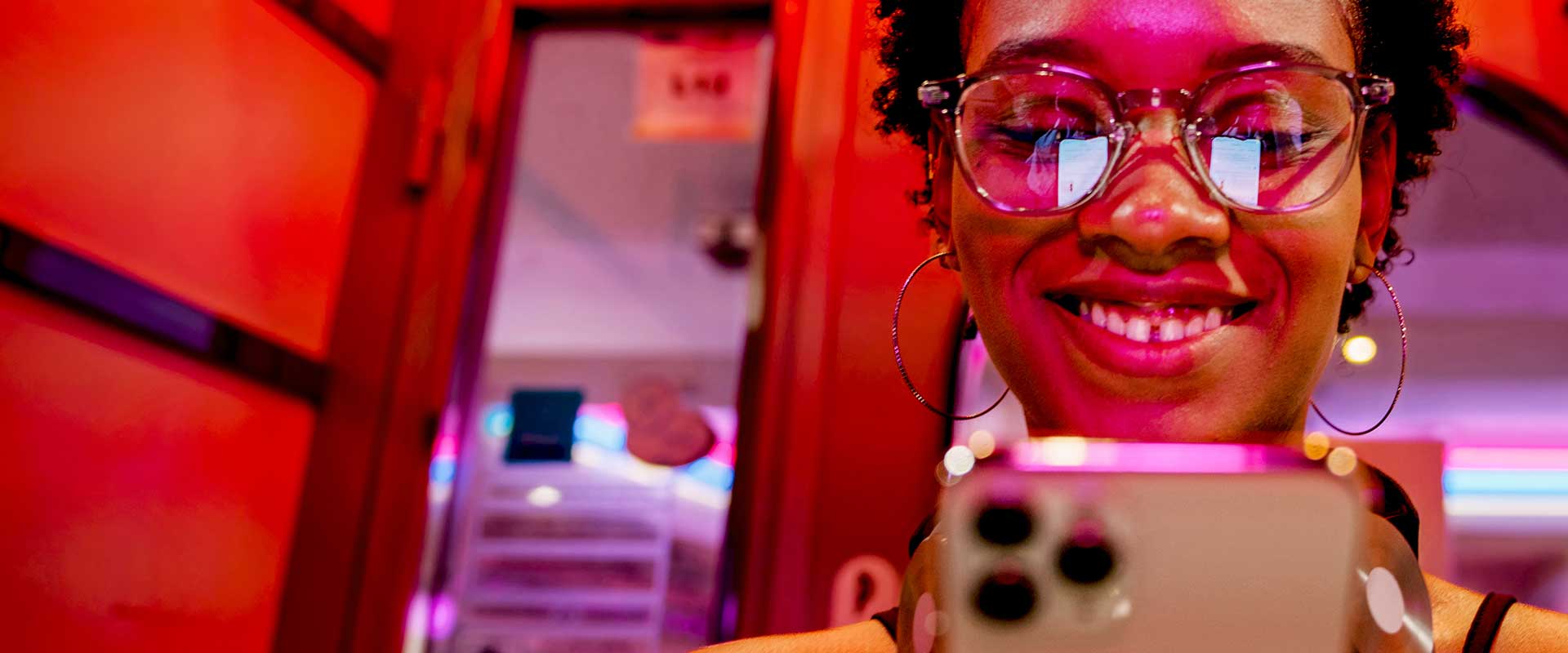 Professional using smartphone in colourful lighting environment