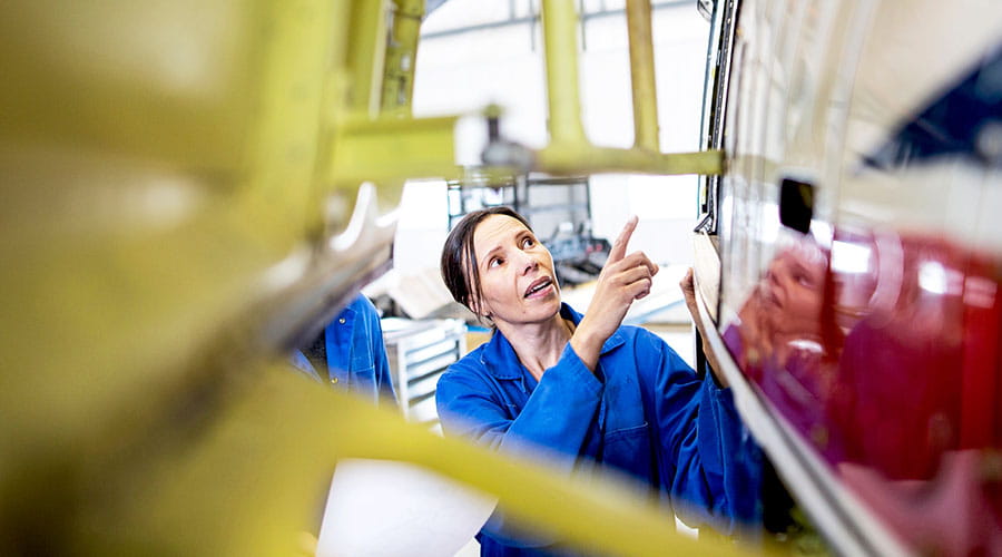 Medewerker assembleert auto onderdelen op productielijn