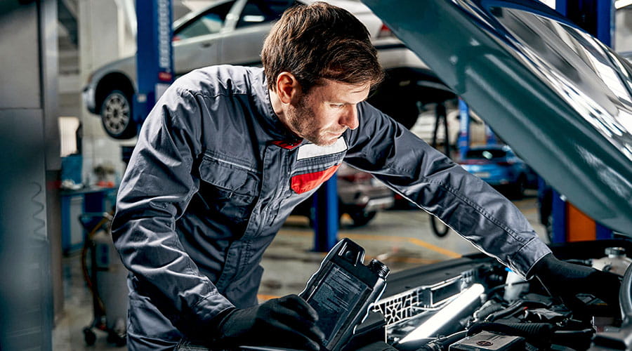 Mecánico trabajando bajo el capó de un automóvil en un taller automotriz