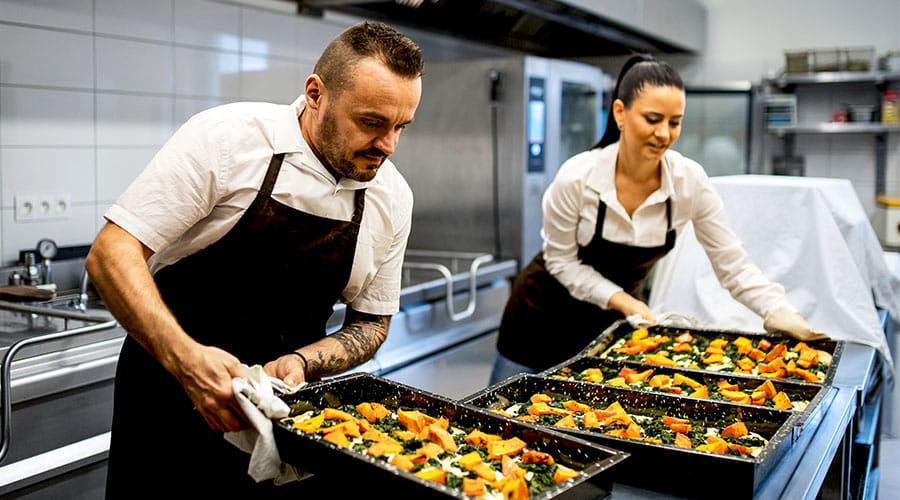 Chefs halen bakken eten uit oven