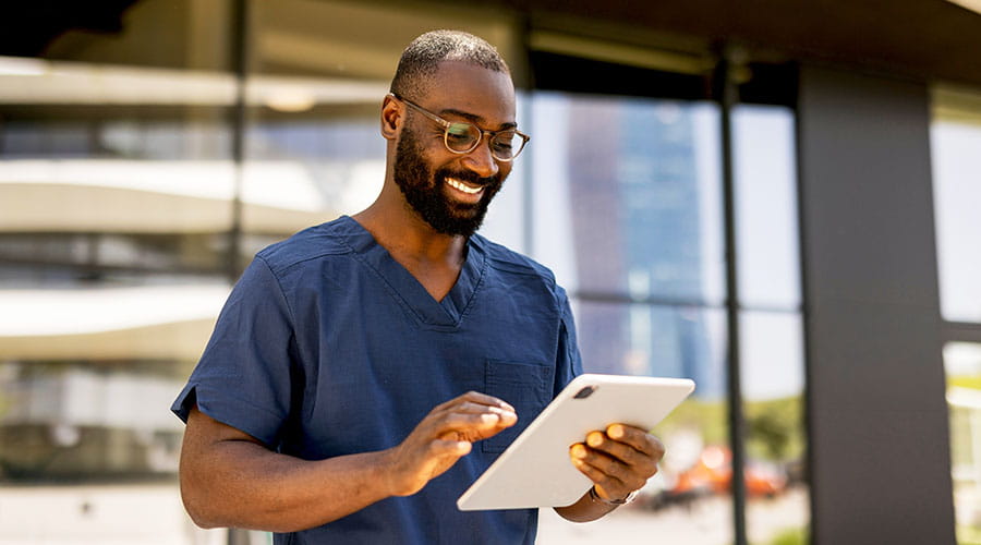 Infirmier examinant les notes d'un patient sur une tablette Infirmier examinant les notes d'un patient sur une tablette