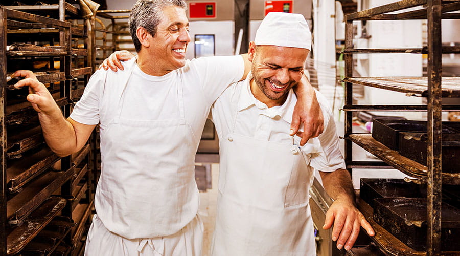 Des travailleurs collaborant dans un environnement de boulangerie ou de production alimentaire Des travailleurs collaborant dans un environnement de boulangerie ou de production alimentaire