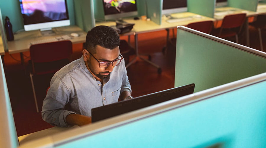 Person working at computer in office cubicle