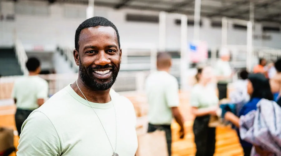 Smiling veteran standing in a busy distribution center
