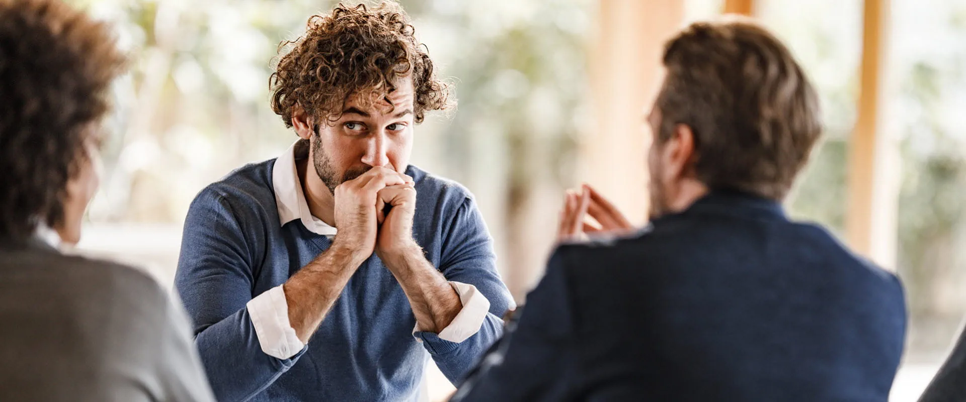 Professionals engaged in a serious discussion in a modern office setting, highlighting thoughtful communication and problem-solving.