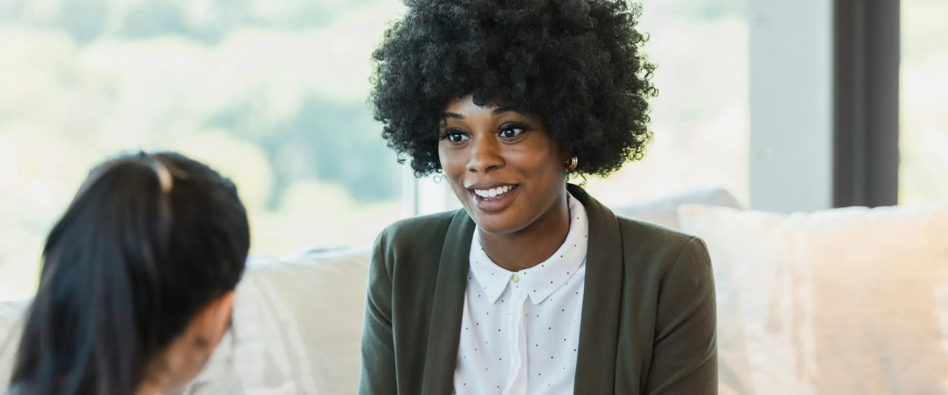 A professional smiling and engaging in a conversation with a colleague in a modern office. A professional smiling and engaging in a conversation with a colleague in a modern office.