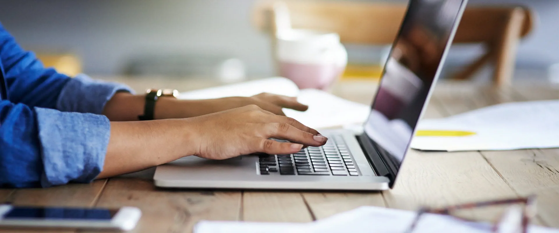 Cropped shot of hands of an individual using a laptop while working from home