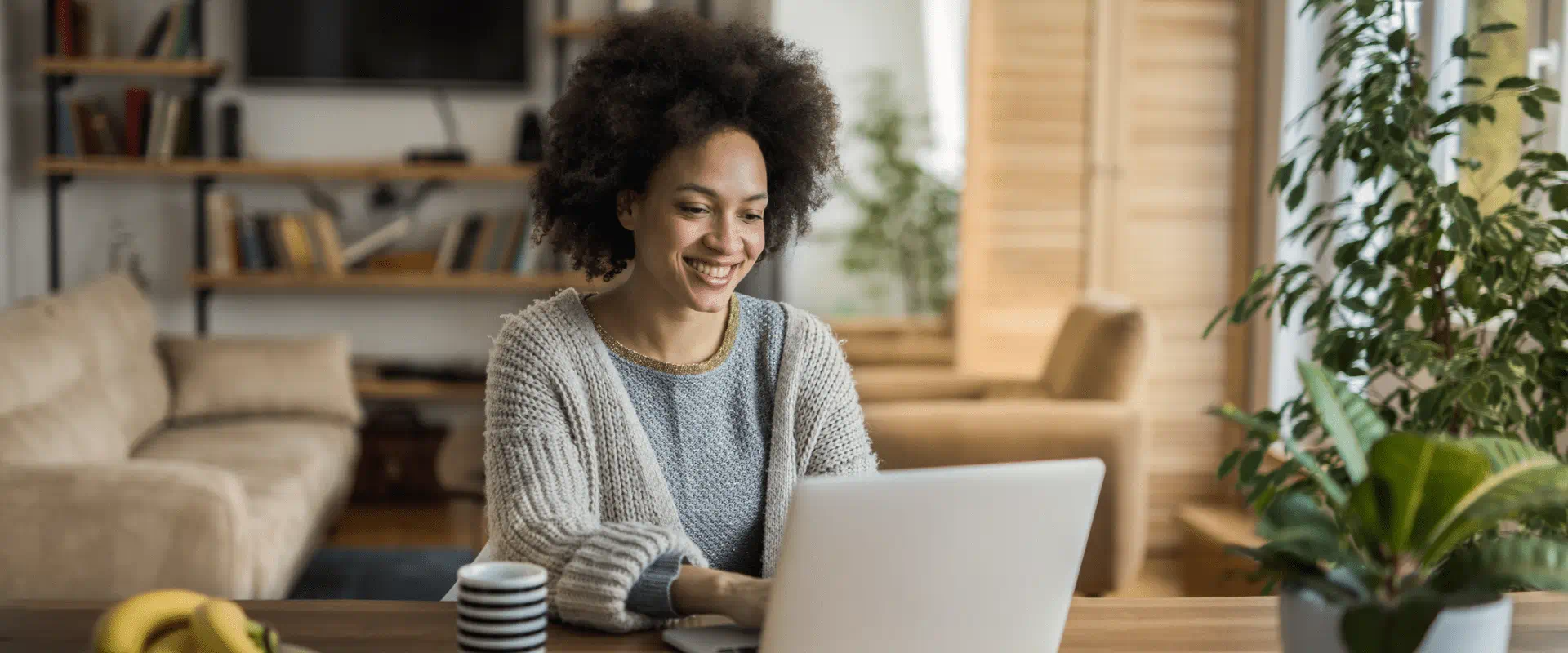 A person sits at their kitchen table at their laptop. 