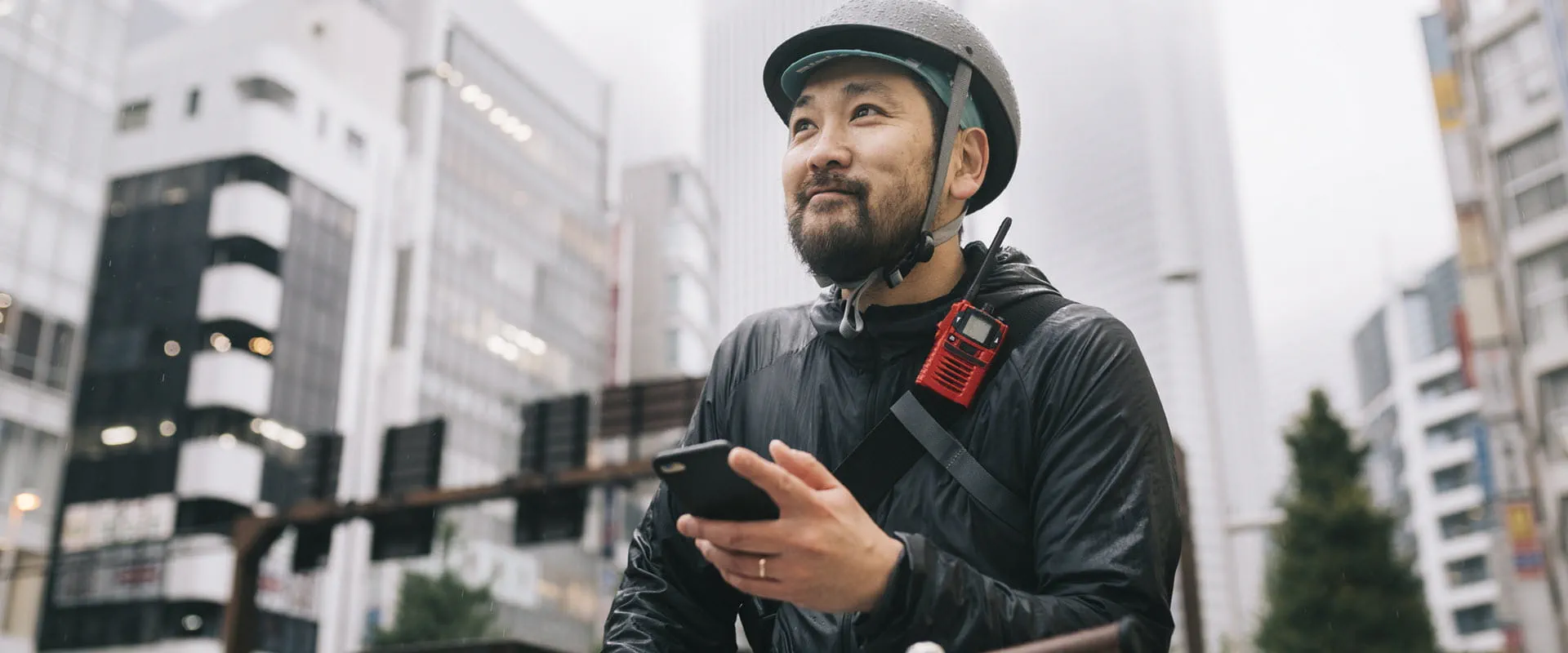 A bike messenger looks up from his phone optimistically.