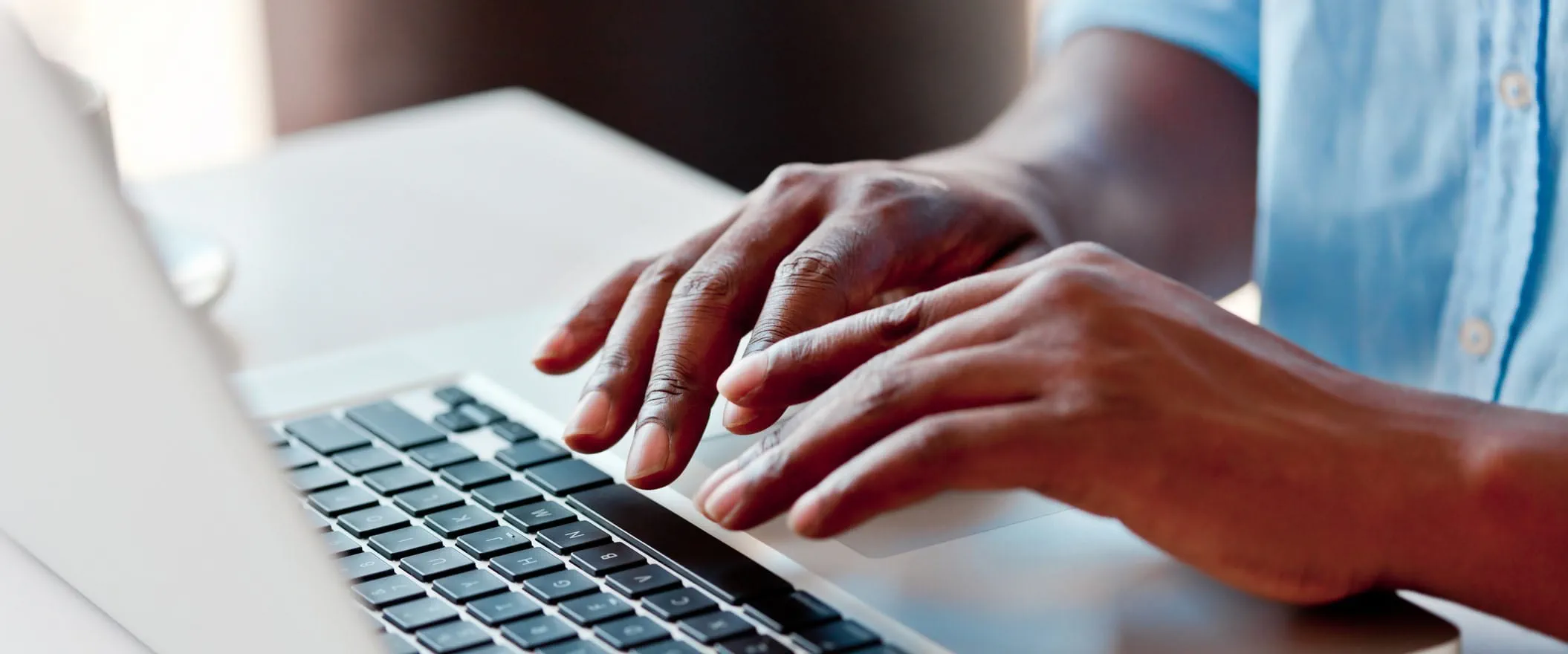 Two hands at a laptop keyboard