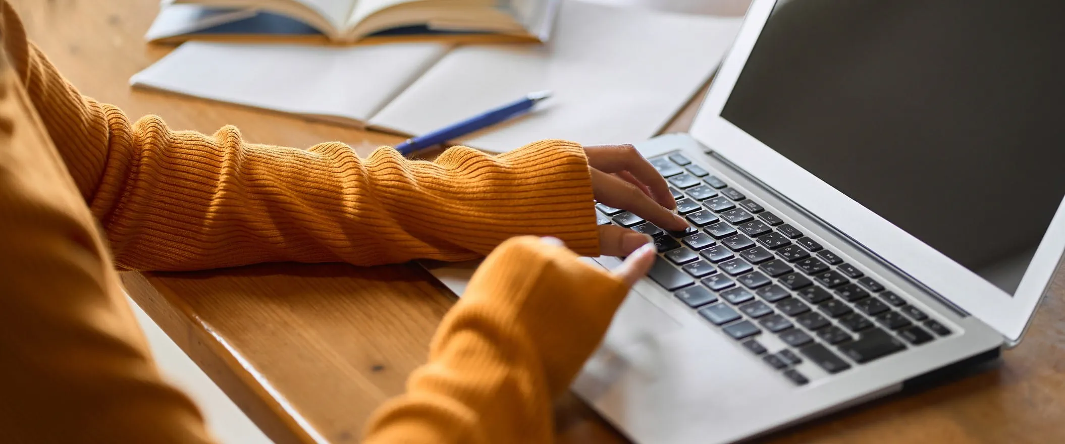 Two hands at a laptop keyboard