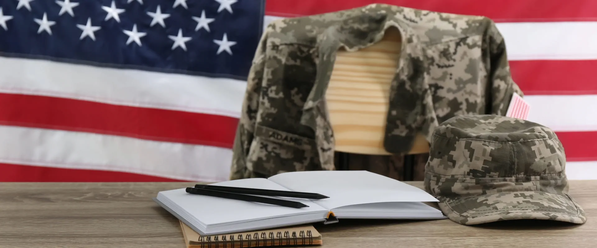 Stationery and soldier uniform near flag of United States.