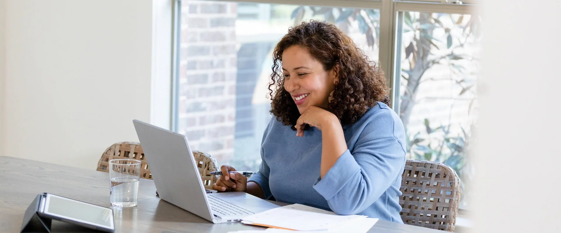 Smiling person looking at laptop, attending a virtual job interview.
