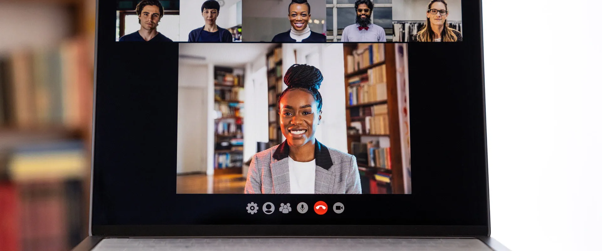 A laptop screen showing group of people on a virtual video call.