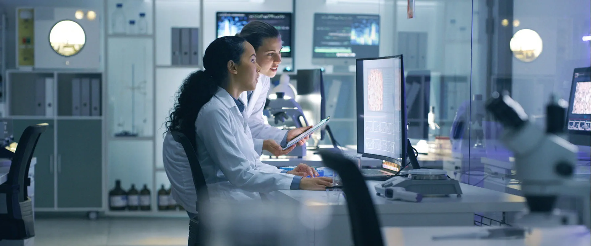 Medical researchers looking at a computer in a lab setting.