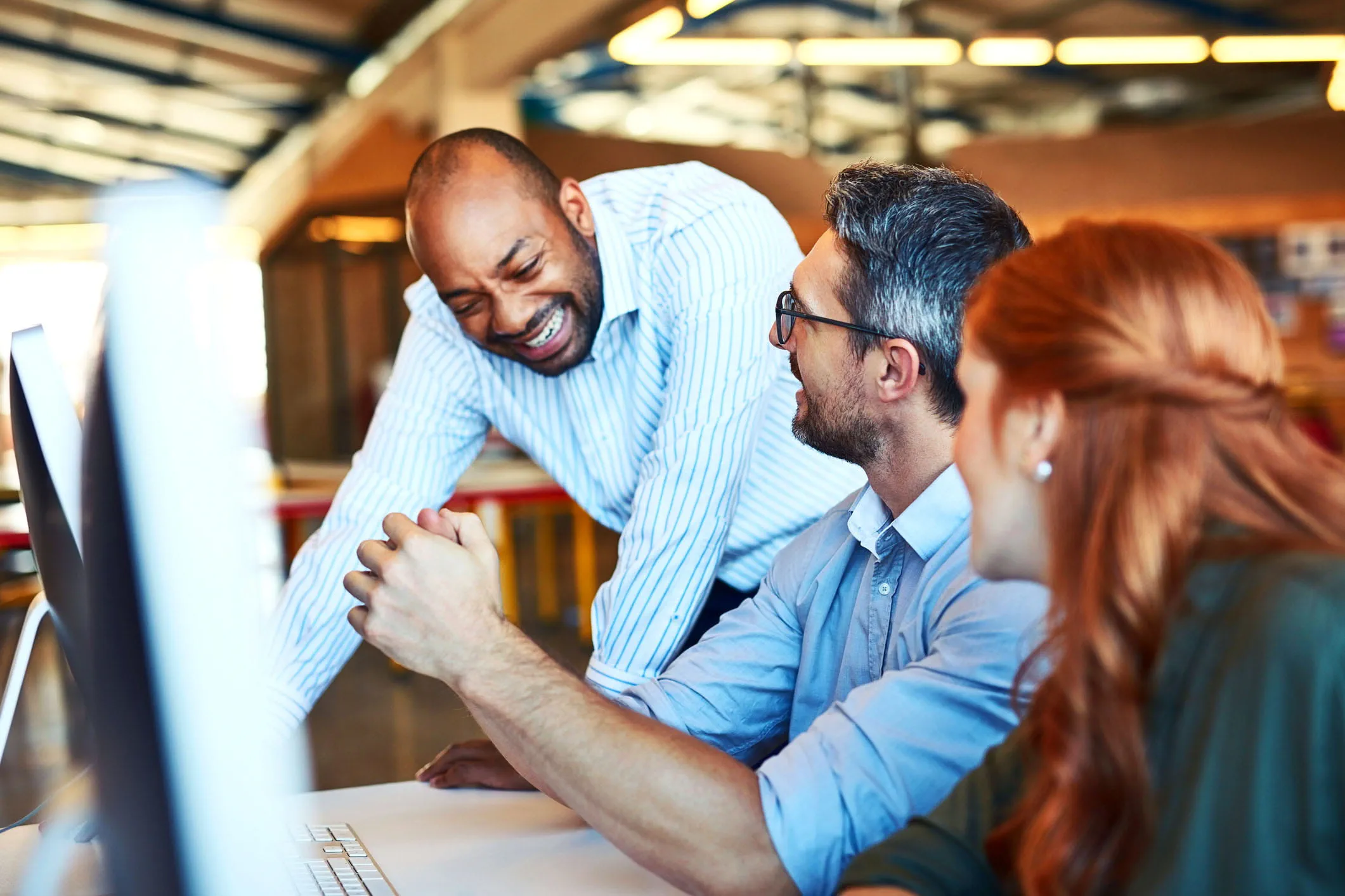 Three coworkers collaborate at a desk