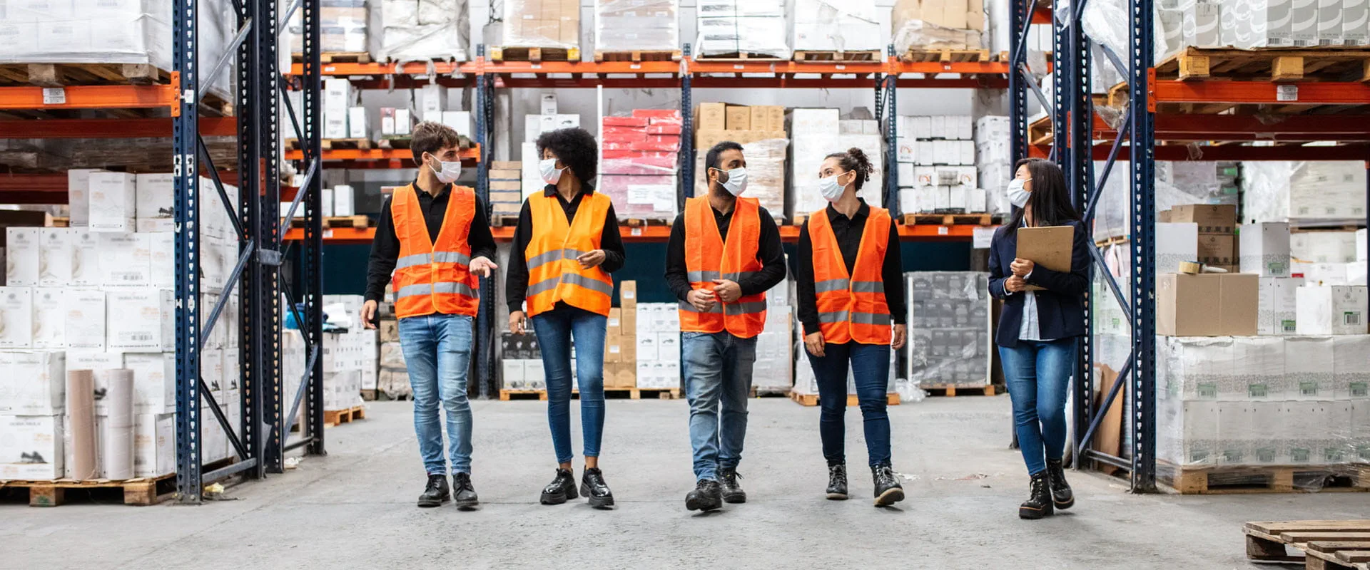 Team of warehouse workers wearing face masks at work