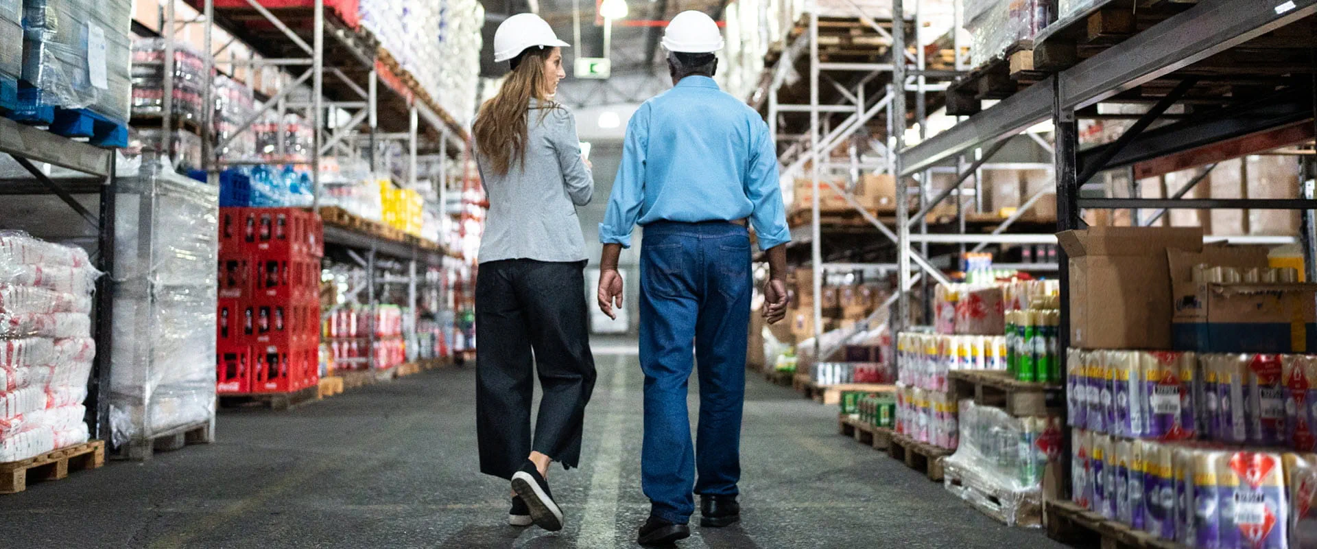 Coworkers talking while walking in a grocery warehouse