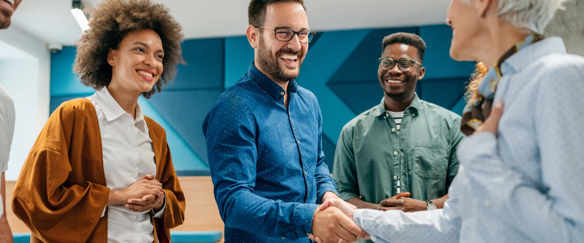 Business person shaking hands with colleague in an office.