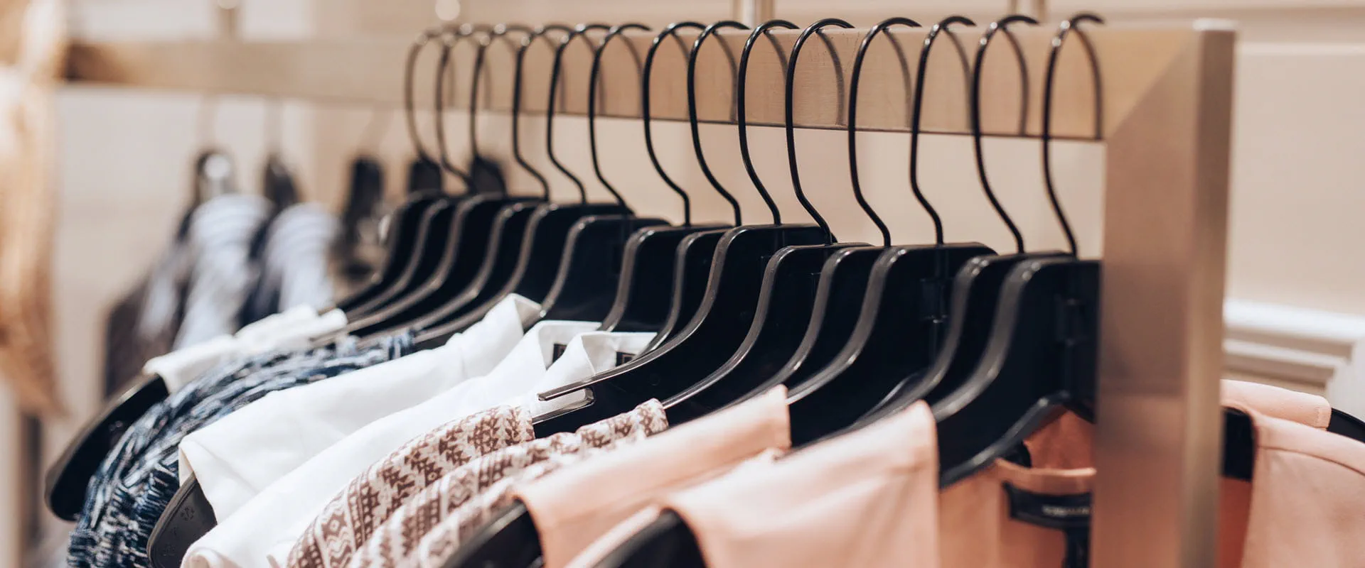 Dresses hanging on a rack in a clothing store.