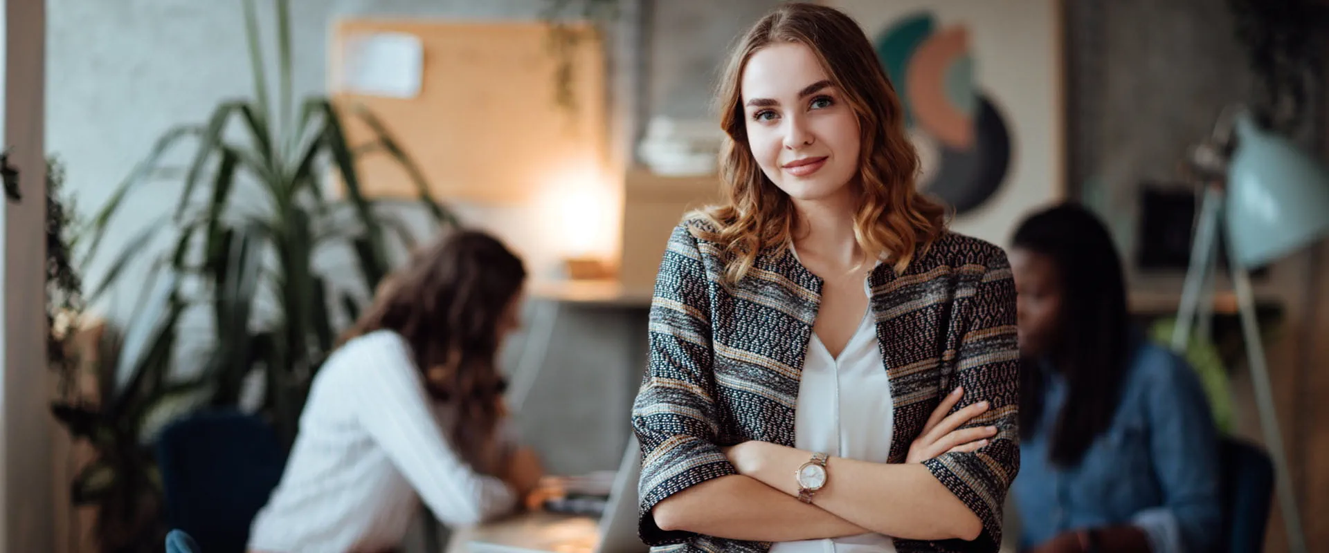 Confidant business person, leaning on table, looking at camera.