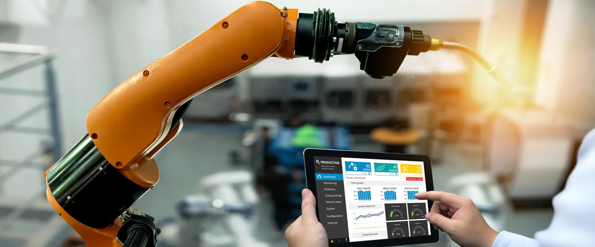 Person using a tablet to control or monitor an industrial robotic arm.