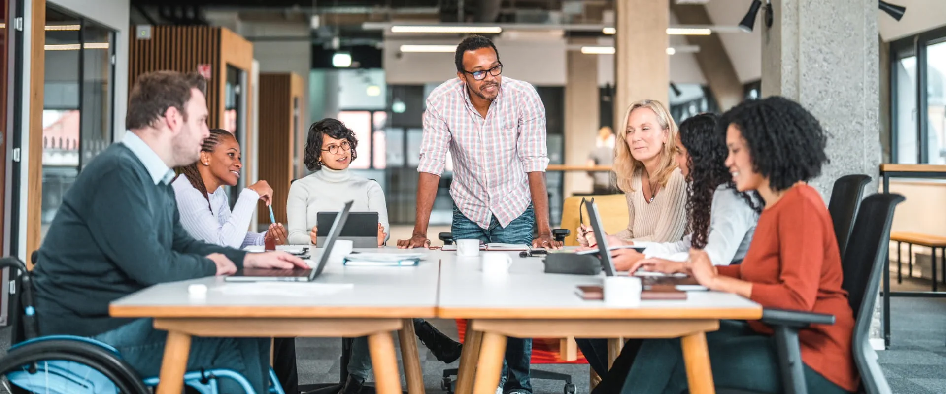 Work meeting being held in an office with a group of diverse people.