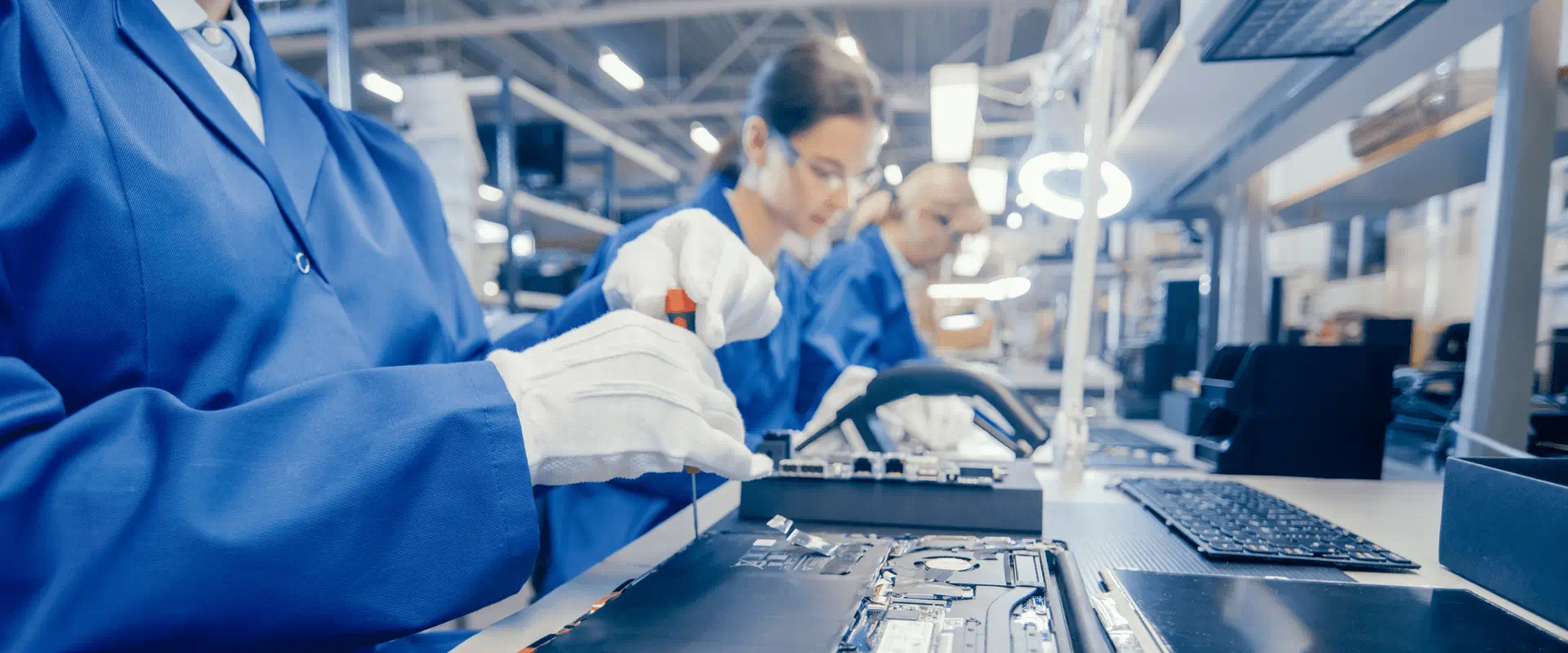 Workers in an assembly line work on computer chips