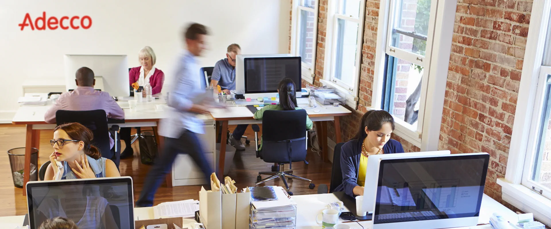 People working in a busy Adecco office.