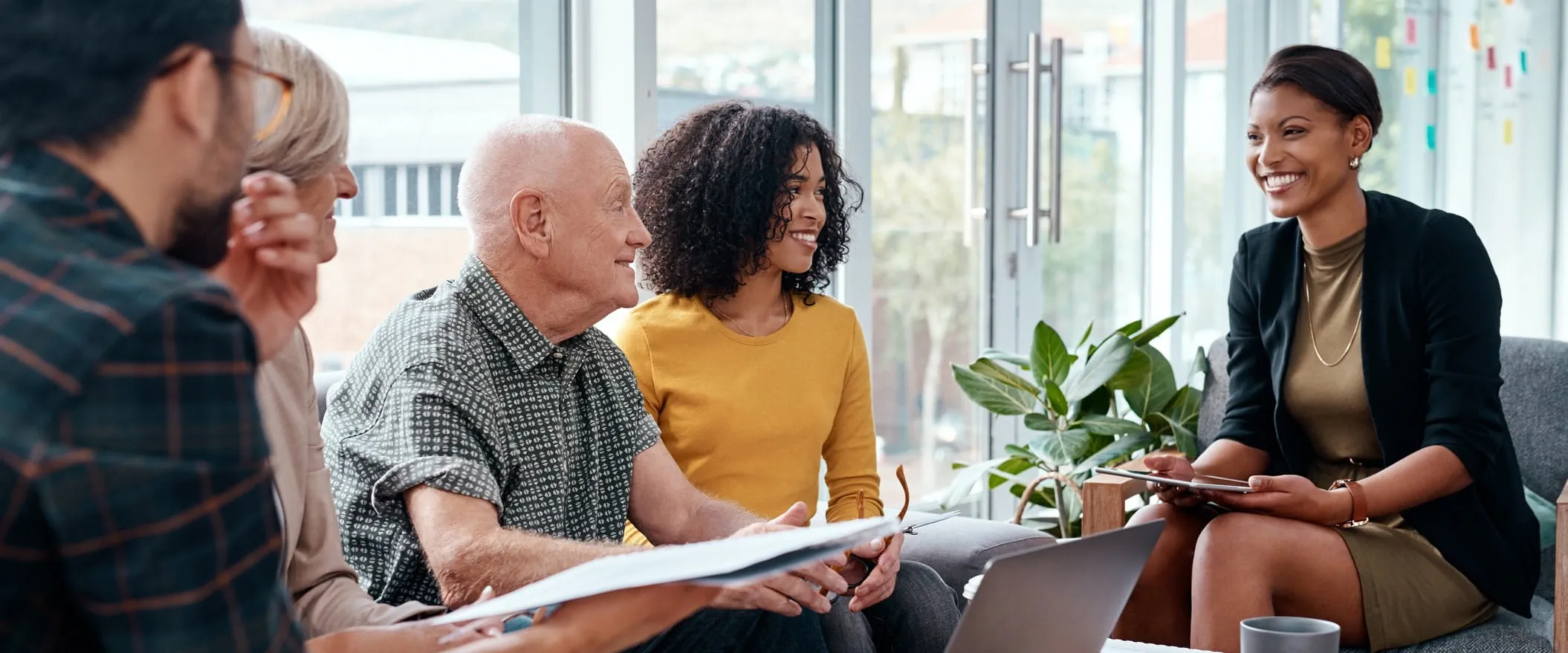 A diverse group of five people sitting together in a well-lit room, engaged in a friendly and productive discussion. A diverse group of five people sitting together in a well-lit room, engaged in a friendly and productive discussion.