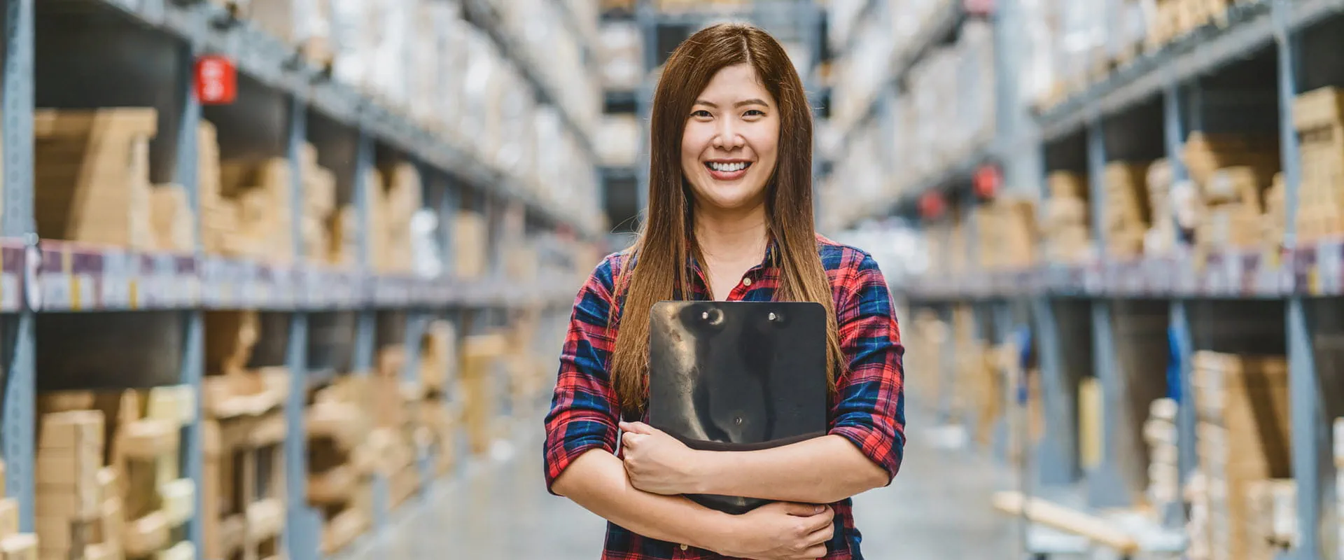Warehouse worker standing and holding a clipboard Warehouse worker standing and holding a clipboard