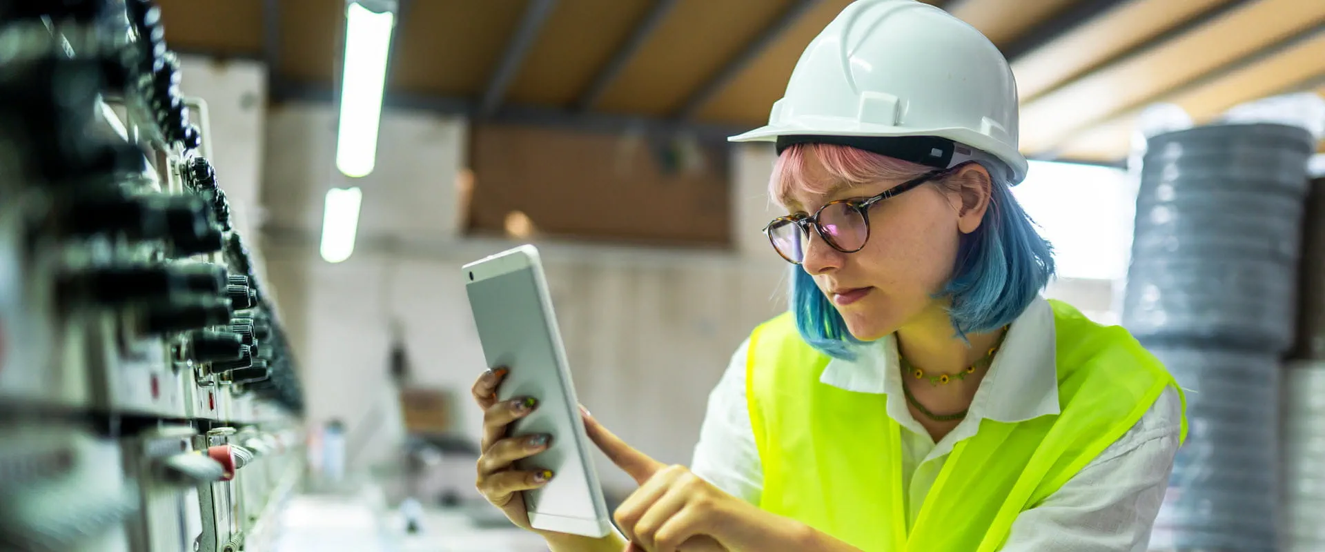 Young female engineer working with manufacturing equipment in a factory.