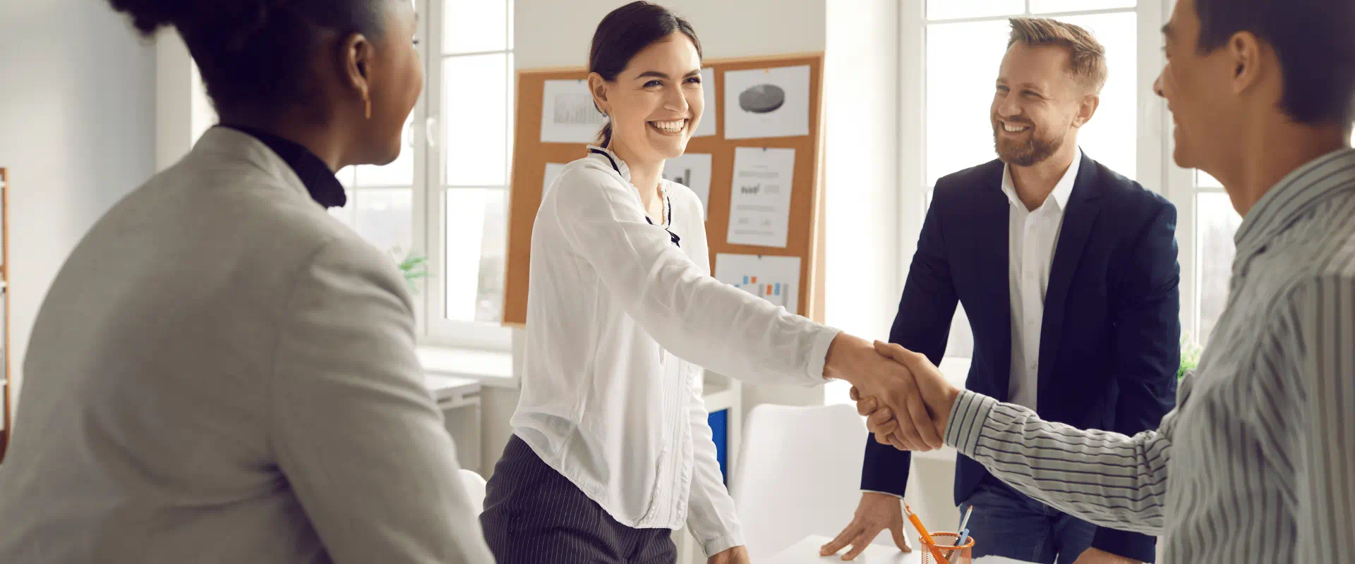 People shaking hands in a professional setting.
