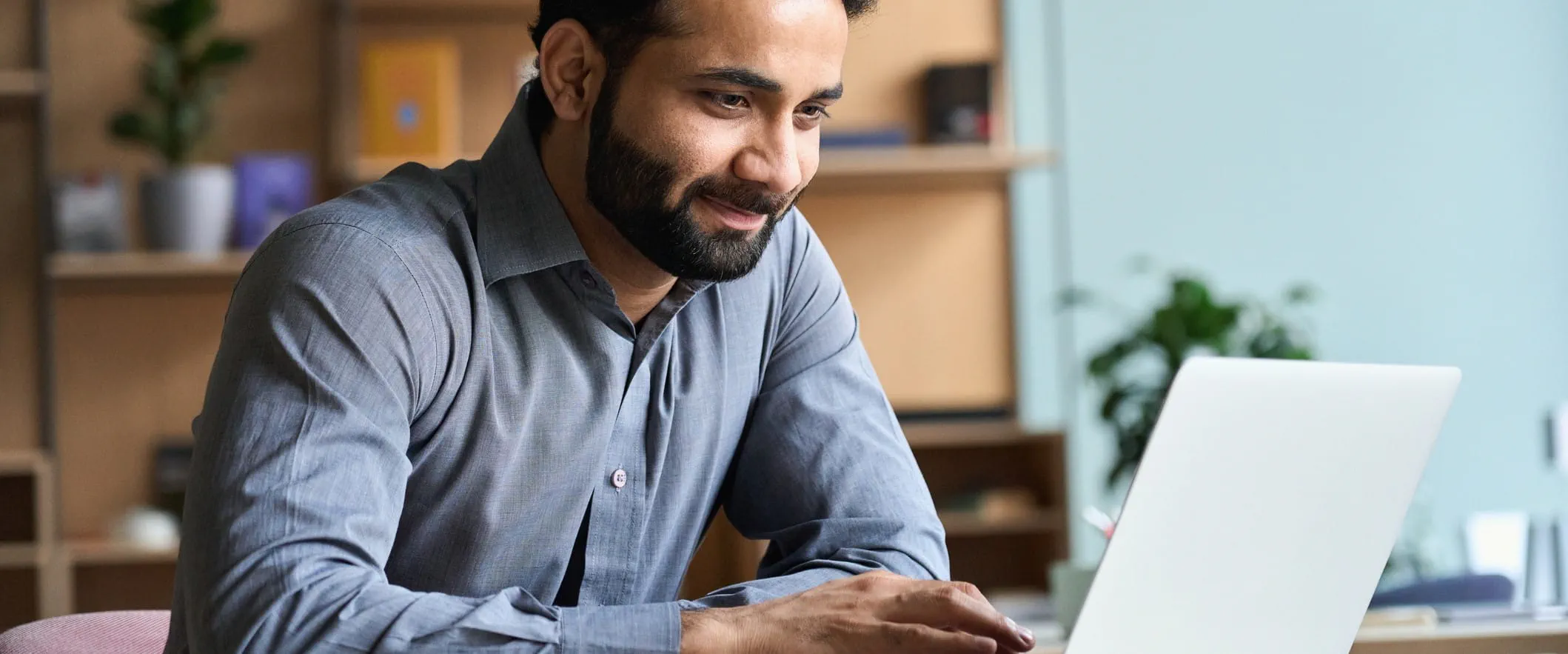 Person sits and works at laptop 