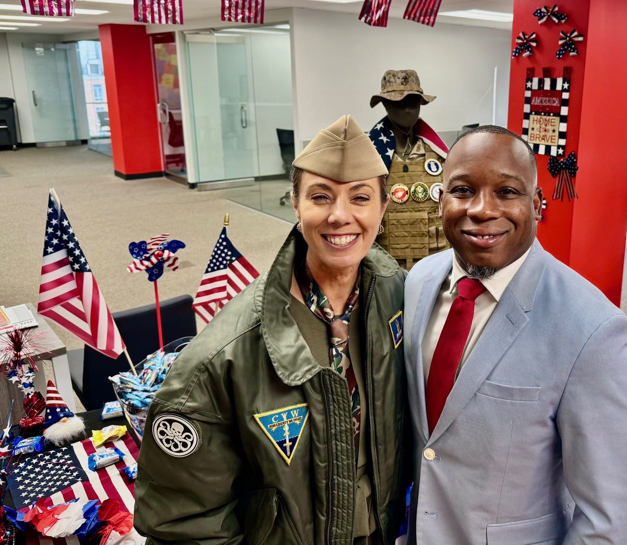 Two colleagues from The Adecco Group take a selfie in front of a table covered in patriotic decorations.